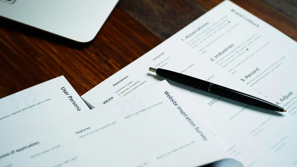 Des documents et un stylo, illustrant la signature d'un contrat de travail et l'importance du conseil juridique pour sa rédaction et sa validation.