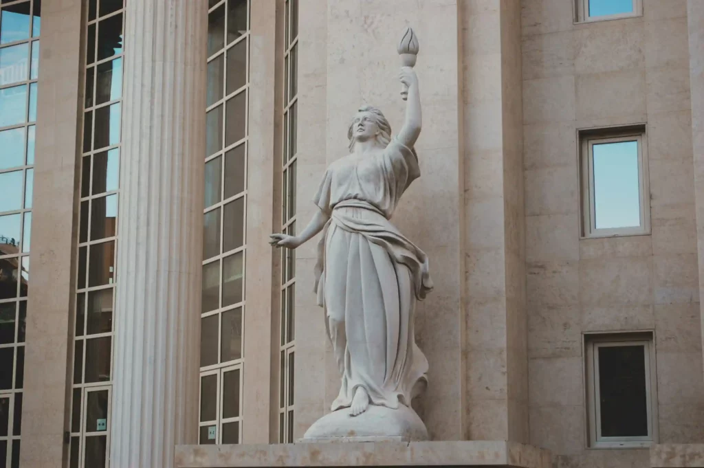 Statue de justice devant un palais de droit, symbole des juridictions civiles chargées de trancher les litiges entre particuliers et de garantir le respect des droits.