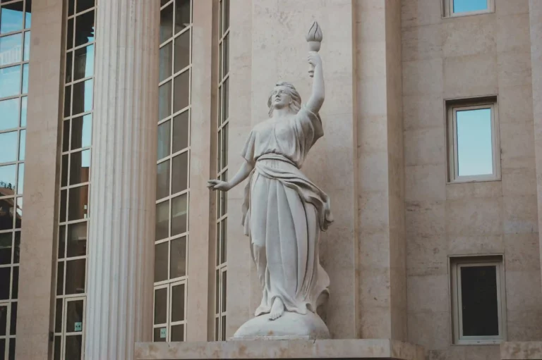Statue de justice devant un palais de droit, symbole des juridictions civiles chargées de trancher les litiges entre particuliers et de garantir le respect des droits.
