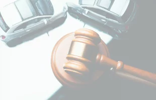 Marteau de juge et voitures de jouet, illustrant un litige en droit civil, un accident de la route, ou un cas de dommage corporel.